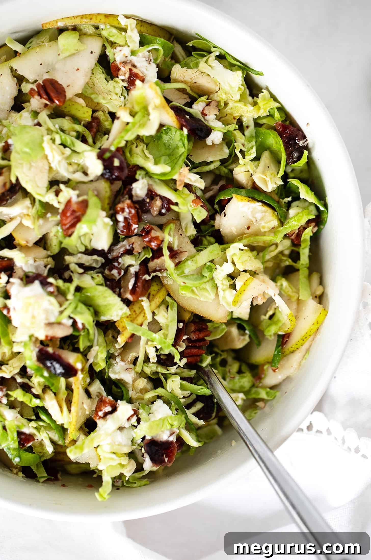 Brussels sprouts and pear salad in bowl with spoon