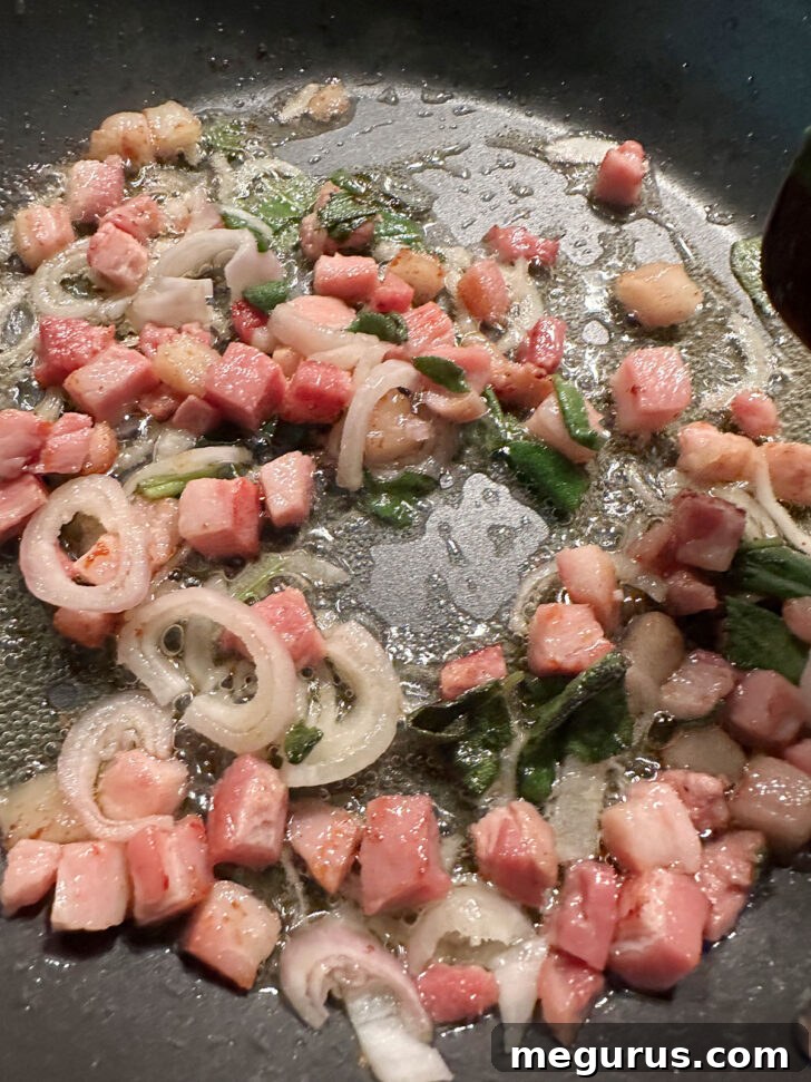 Thinly sliced shallots and fresh sage leaves added to the skillet with cooked pancetta.