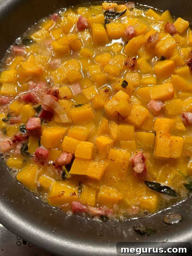 White wine and chicken broth simmering in the skillet with the butternut squash mixture.