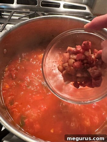 Returning the crispy pancetta to the soup.