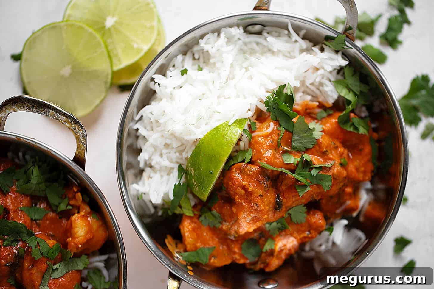 Delicious Shrimp Tikka Masala served in copper bowls with fluffy basmati rice, garnished with fresh cilantro.