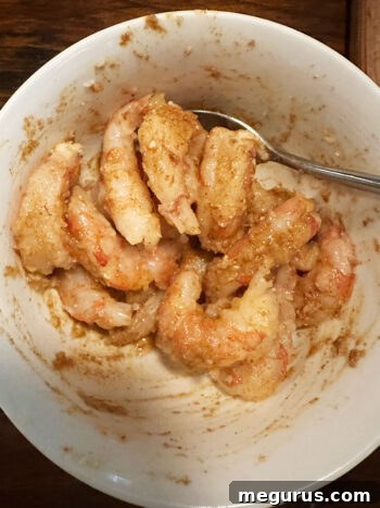 Shrimp in a bowl after being thoroughly stirred with the marinade and spices.