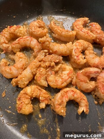 Shrimp being cooked in a hot skillet until just done.
