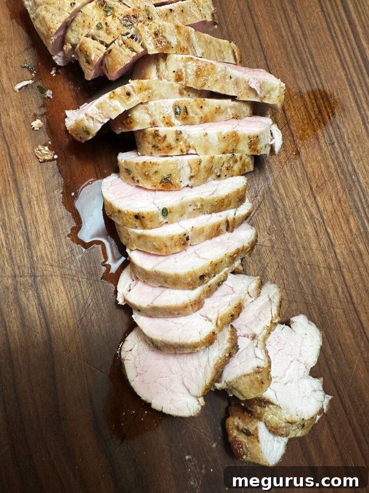 Perfectly sliced pork tenderloin resting on a cutting board, showcasing its juicy interior.