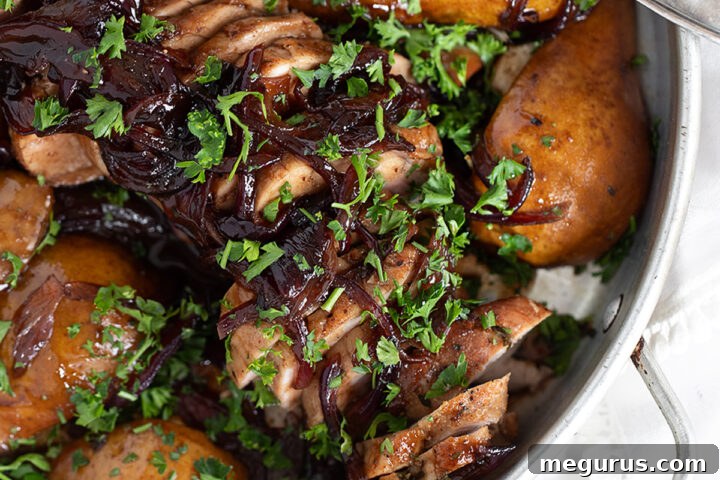 Pork tenderloin with pears and balsamic onions, beautifully presented in a rustic serving dish.