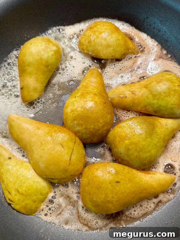 Sautéing pear quarters in melted butter in a hot skillet.