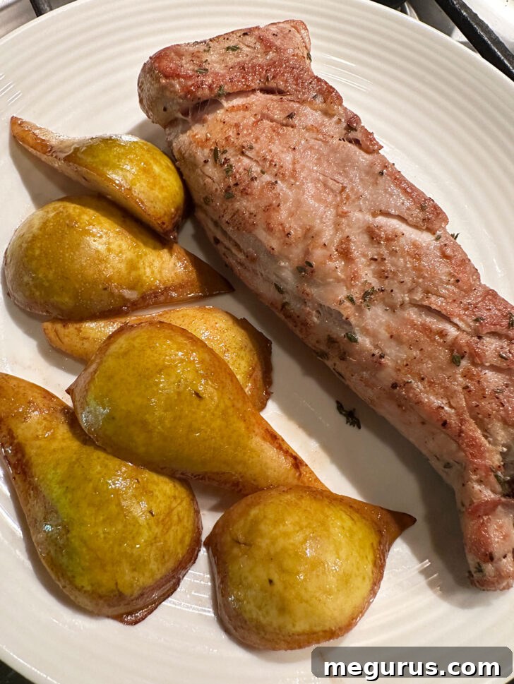 Browned pork and sautéed pears resting together on a plate.
