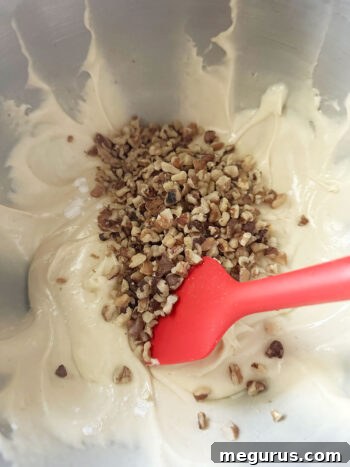Chopped toasted walnuts being folded into the blondie batter.