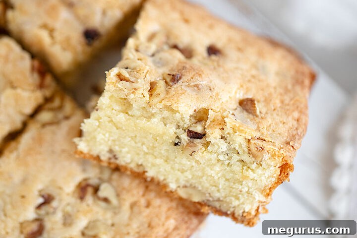 Close-up of a perfectly baked maple walnut blondie, highlighting its rich texture and nutty inclusions.