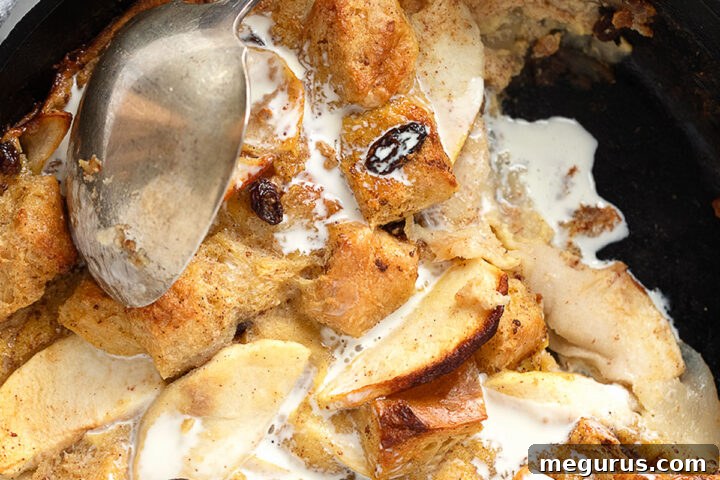 Delicious Apple Bread Pudding in Cast Iron Skillet, ready to be served with a drizzle of cream
