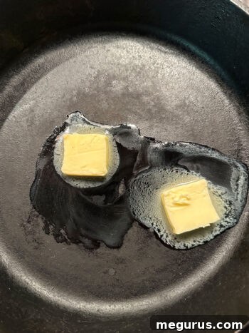 Melting butter in a cast iron skillet, the first step for sautéing apples