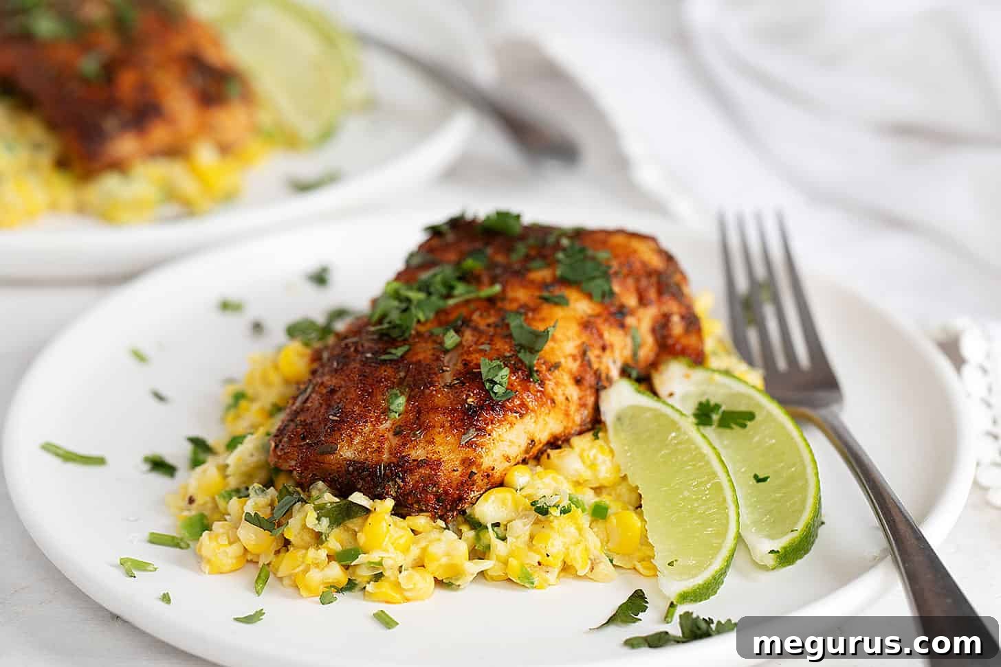 blackened cod on plate with creamed corn, garnished with fresh cilantro