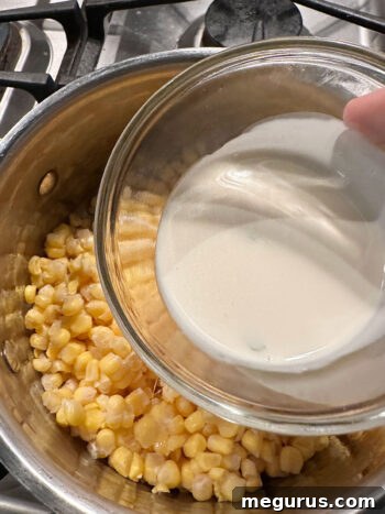 adding cream to corn in saucepan for creamed corn recipe