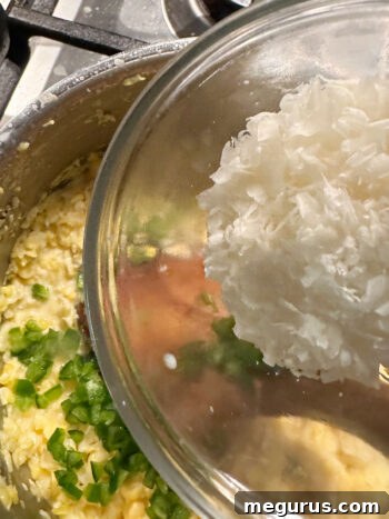 adding jalapeño and Parmesan to saucepan of creamed corn