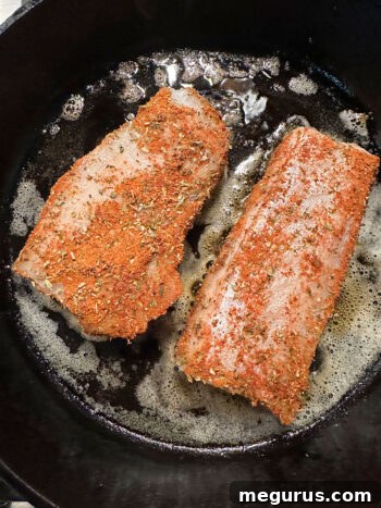 adding rubbed cod to hot skillet for blackening