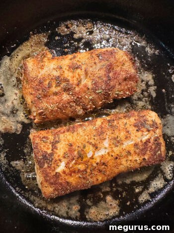 flipping cod in skillet to cook the other side