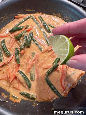 Squeezing fresh lime juice into the finished curry sauce