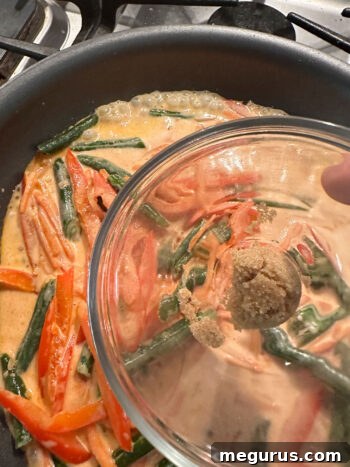 Sprinkling brown sugar into the curry sauce
