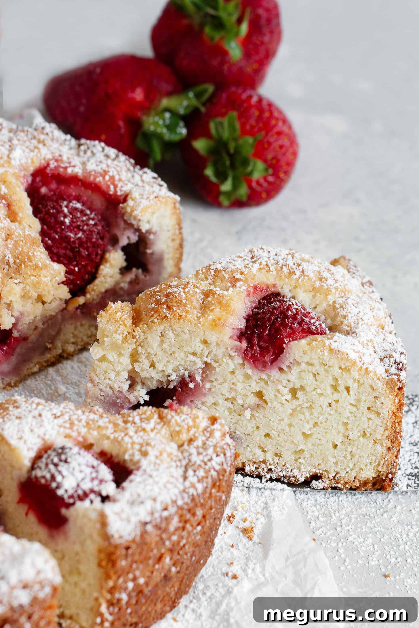 A close-up of the rustic strawberry cake, showing the golden-brown crust and juicy strawberries on top, ready to be served.