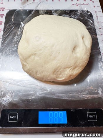 Weighing the dough to ensure even division for consistent roll sizes.