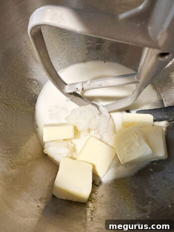Mashed potato, butter, and milk added to the mixing bowl with other ingredients.