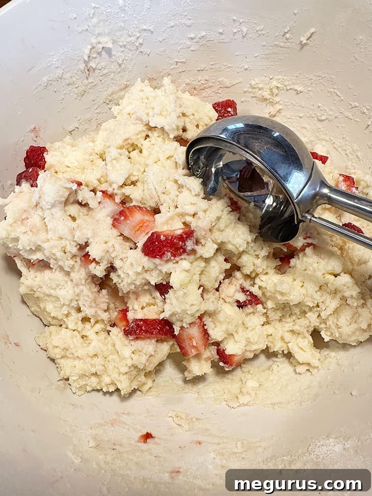 Thick, sticky muffin dough after folding in strawberries, ready for scooping