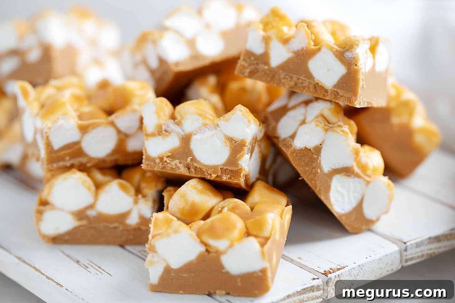 Perfectly cut peanut butter marshmallow squares arranged on a rustic serving board, ready to be enjoyed.