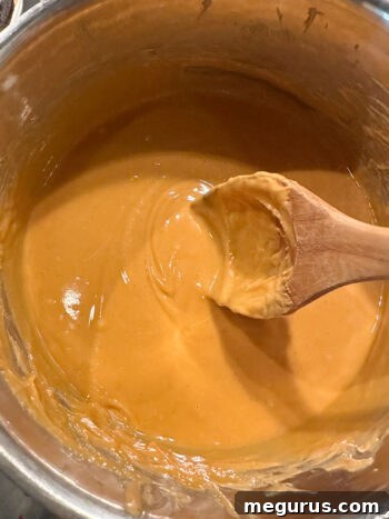 The melted peanut butter, butterscotch, and butter mixture, smooth and glossy, after being removed from heat.