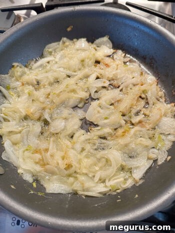 Onions in a skillet, turning a light golden-brown as they begin to caramelize, releasing their natural sugars.