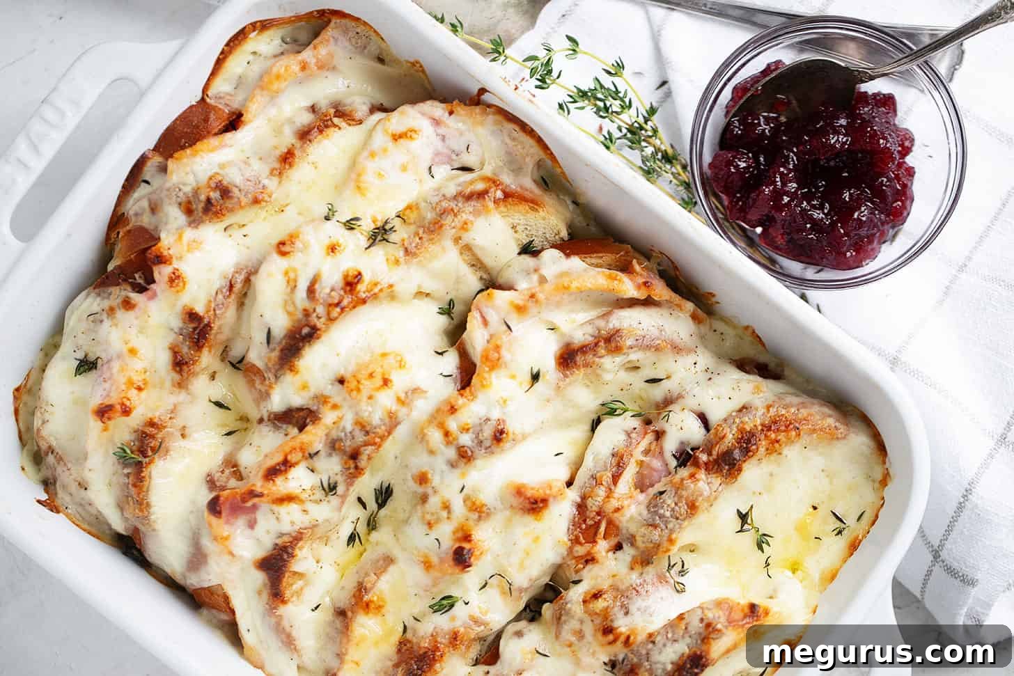 Croque Monsieur casserole in baking dish with cranberry sauce on the side, ready to serve