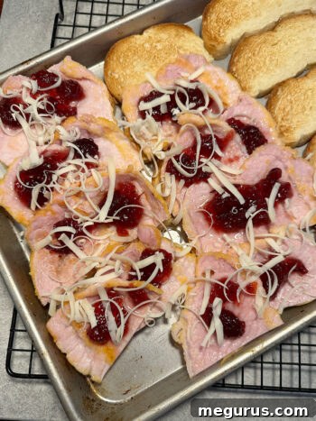 assembling sandwiches with peameal bacon, cranberry sauce, and cheese