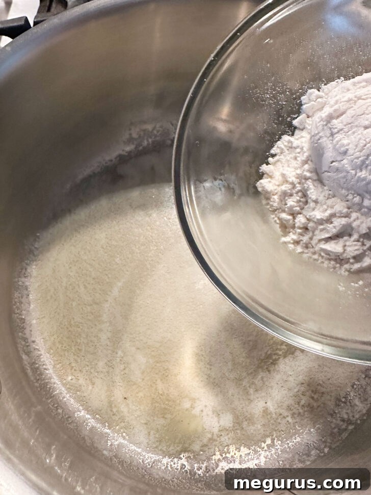 adding flour to melted butter in saucepan