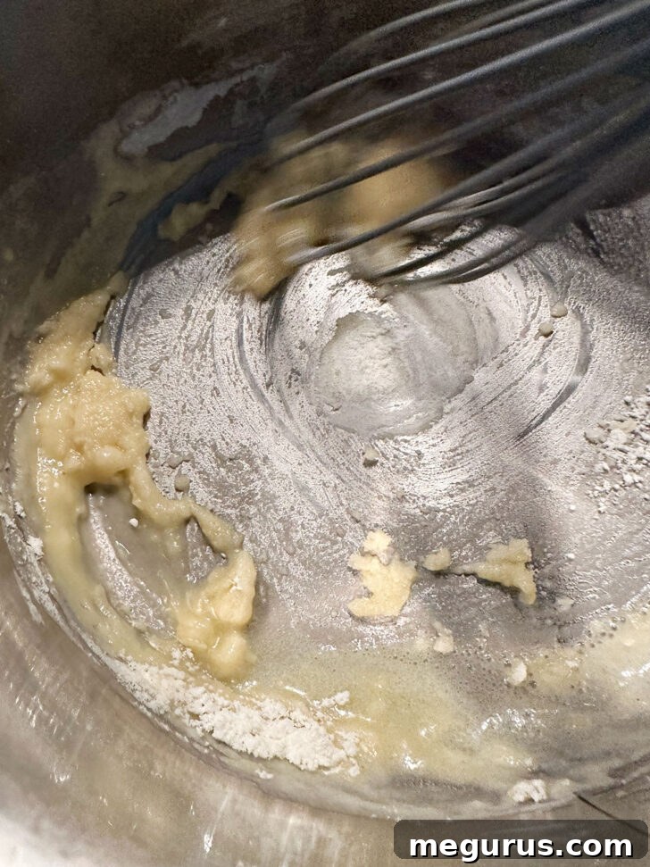 whisking butter and flour together to make a roux