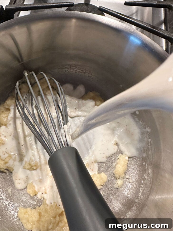 gradually adding milk to butter and flour mixture
