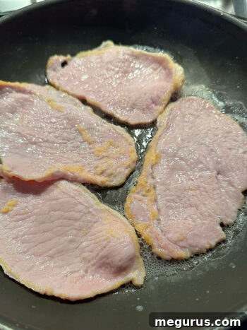 cooked peameal bacon slices on a plate