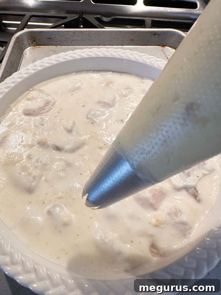 Mashed potatoes in a piping bag with a star tip, ready for topping the fish pie