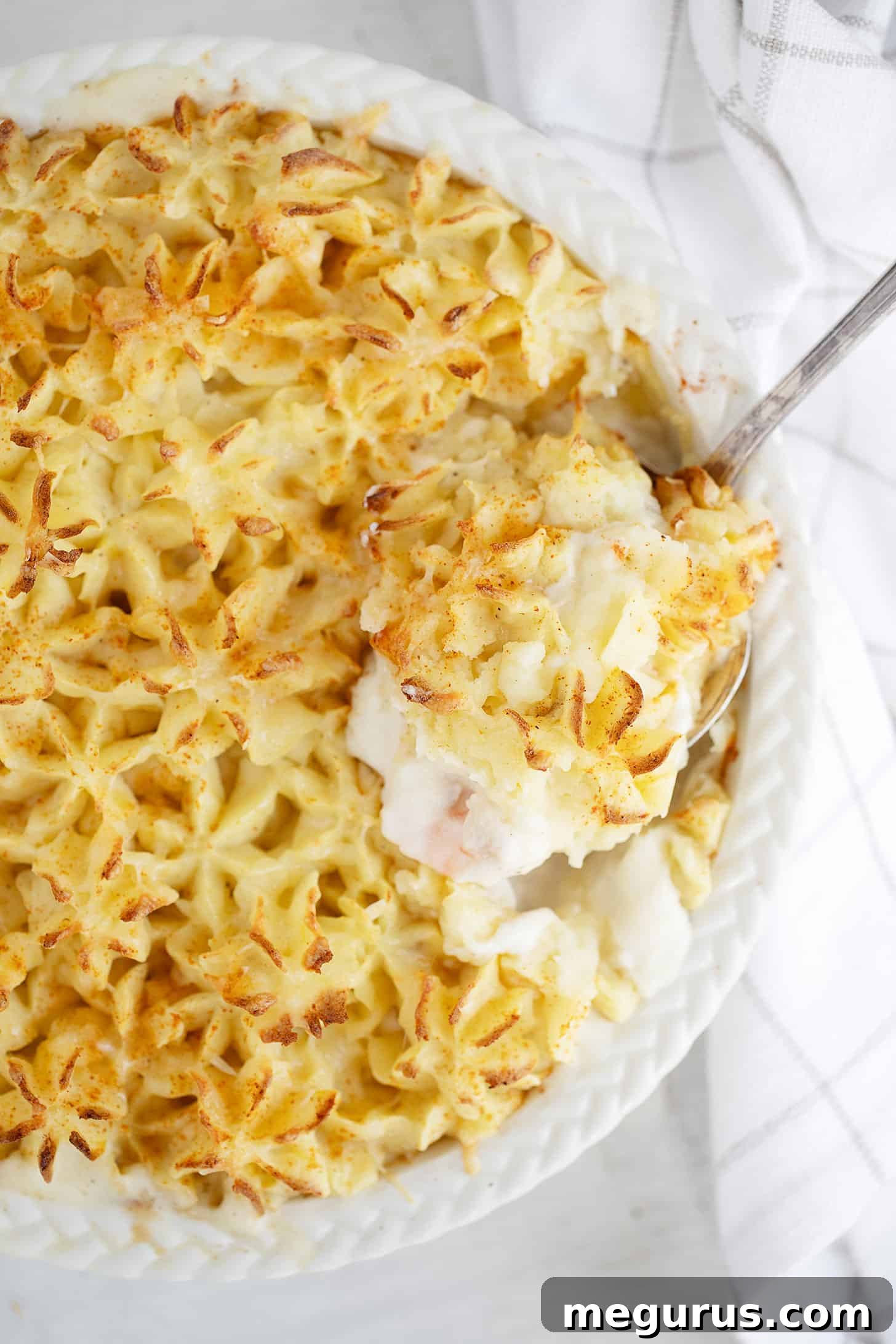 Close-up of a serving of Fish Pie on a plate, showing the creamy filling and golden mashed potato topping