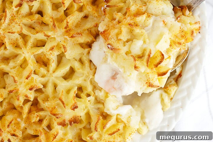 Fish pie in baking dish with spoon