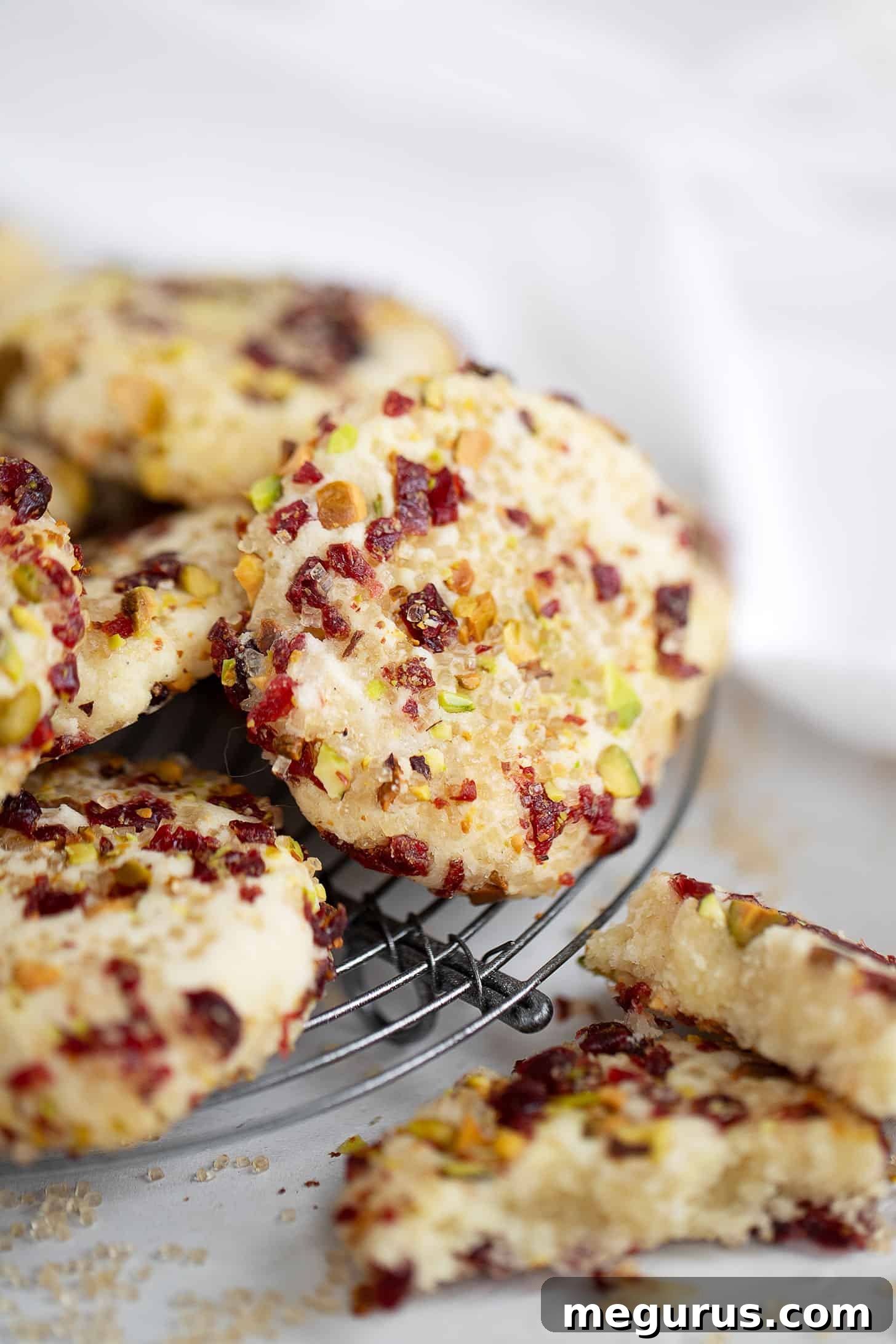 Close-up of baked pistachio cranberry shortbread cookies, perfectly golden and cooling on a wire rack.