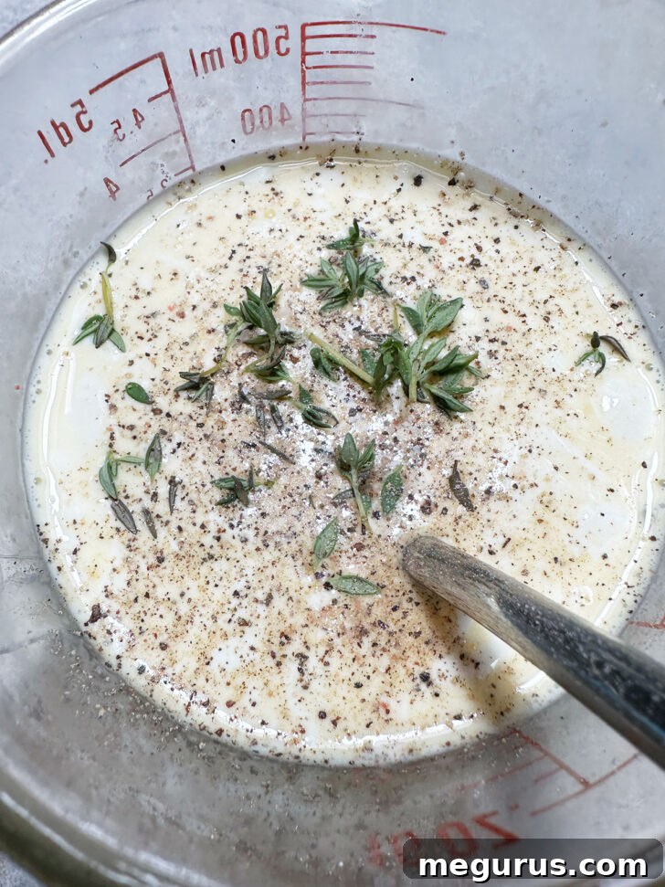 Adding salt, pepper, and fresh thyme leaves to the egg and cream mixture for seasoning.
