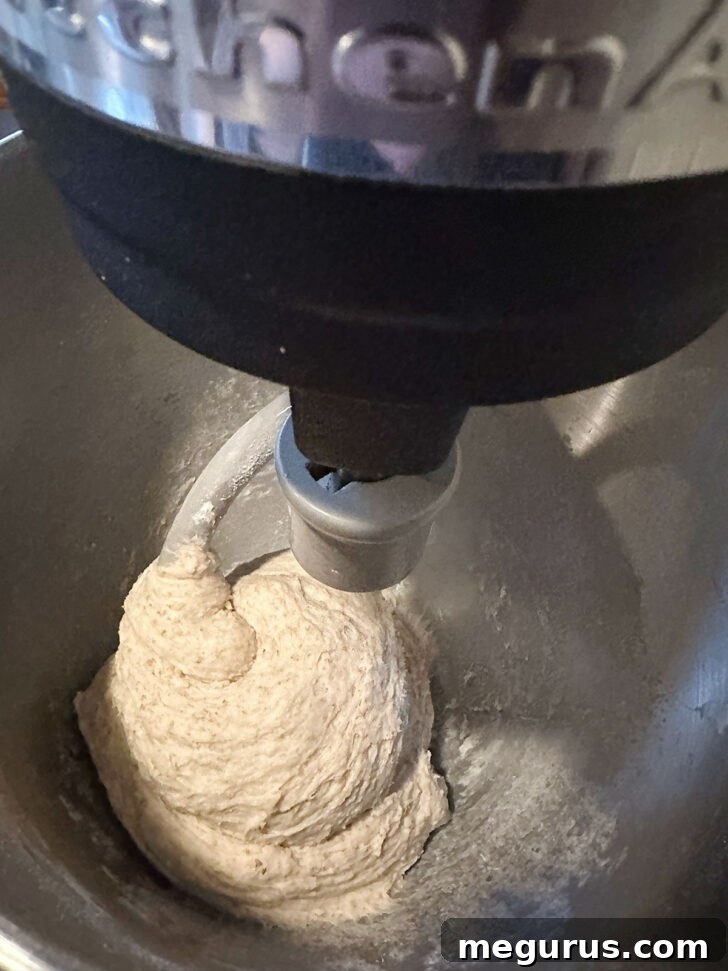 Finished bread dough in a stand mixer, demonstrating proper consistency after kneading.