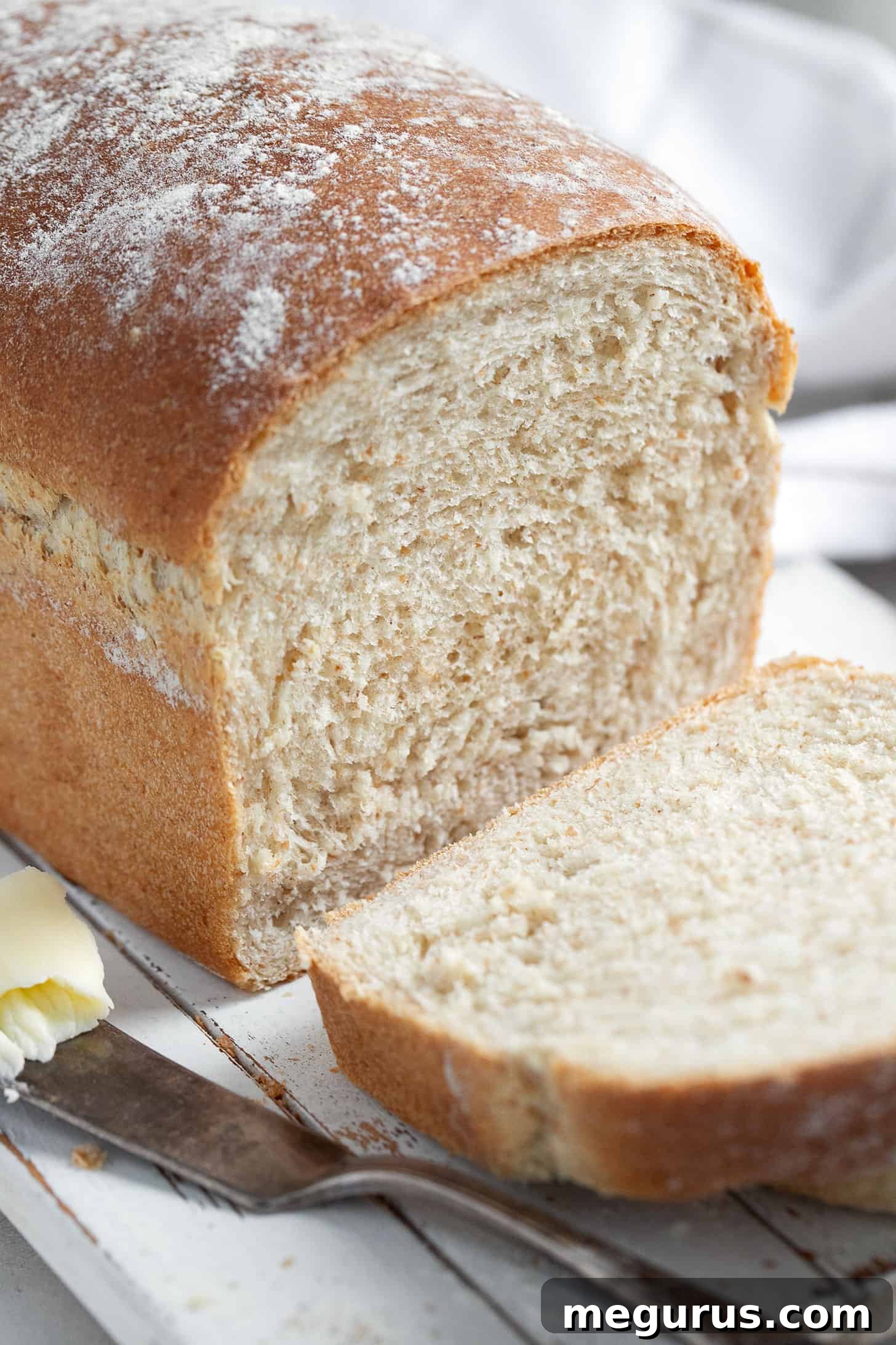 Beautifully sliced honey whole wheat bread on a rustic cutting board, showcasing its tender crumb.