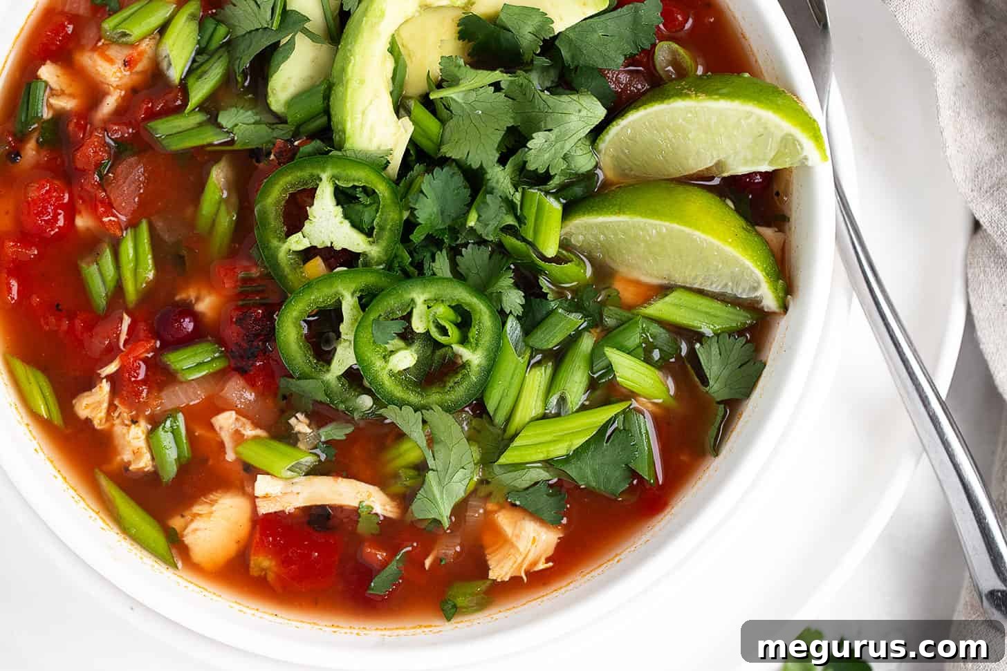 Hearty Mexican Chicken Soup served in a white bowl with fresh garnishes