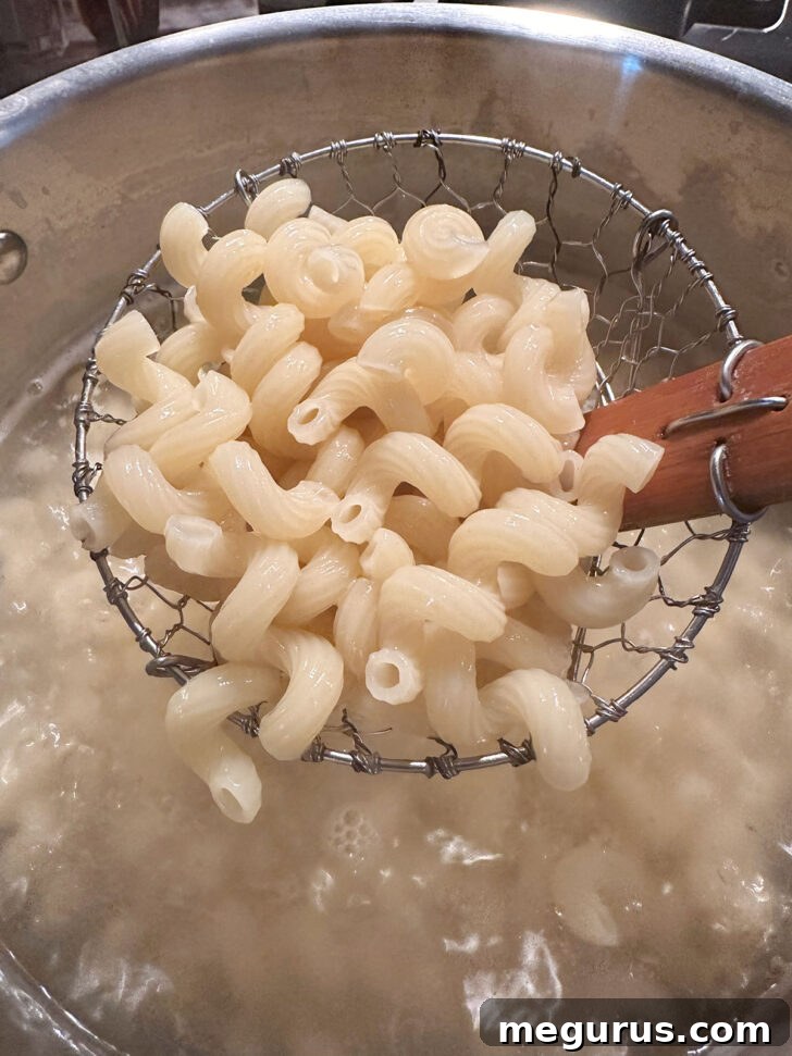 Transferring cooked pasta from boiling water directly into the sauce.