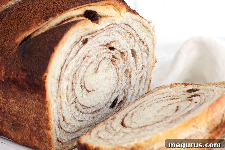 Cinnamon raisin bread sliced on cutting board.