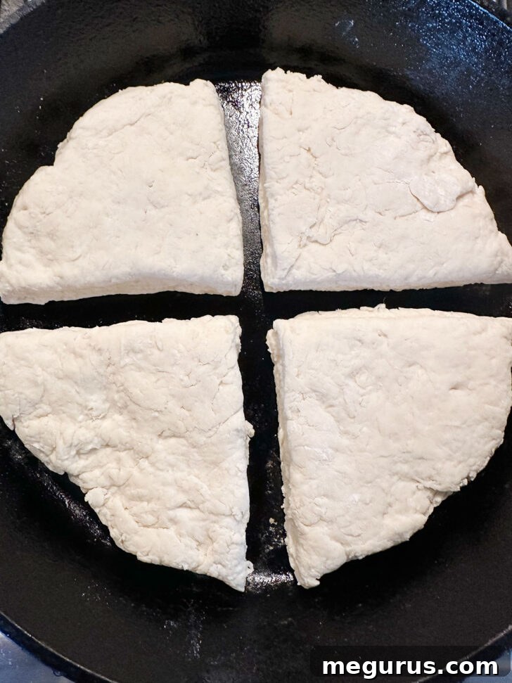 Dough quarters placed in a warm cast iron skillet.