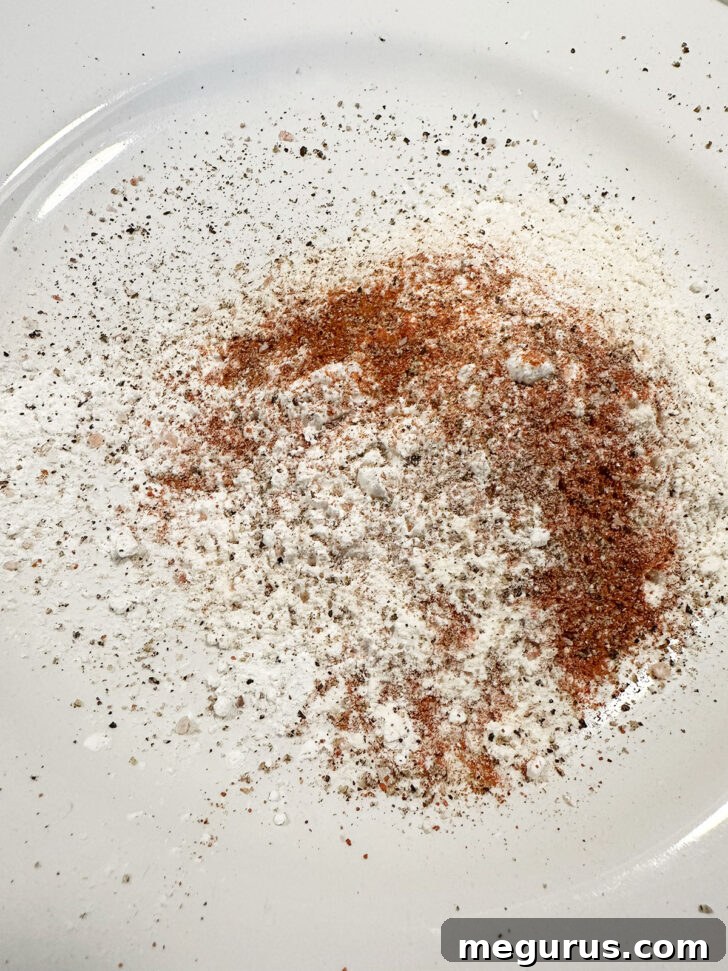 Flour coating ingredients on plate.