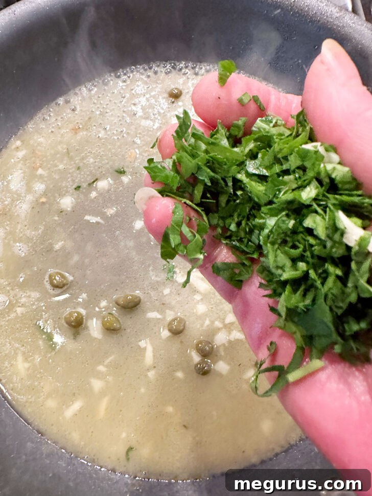 Adding parsley to the skillet with the sauce.