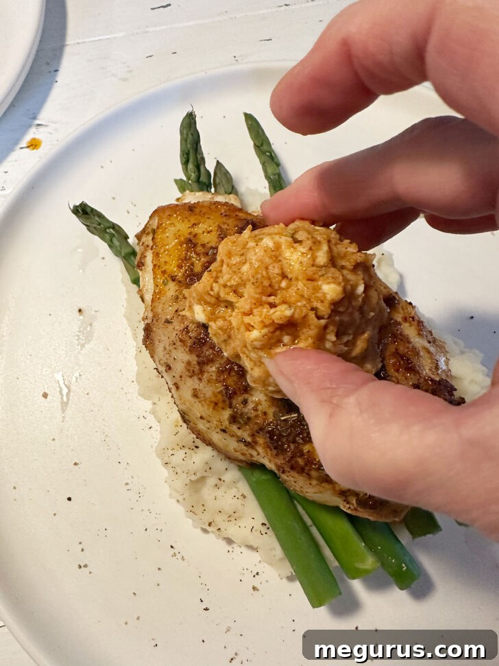 Adding a dollop of melting honey butter to the top of a hot Cajun chicken breast.