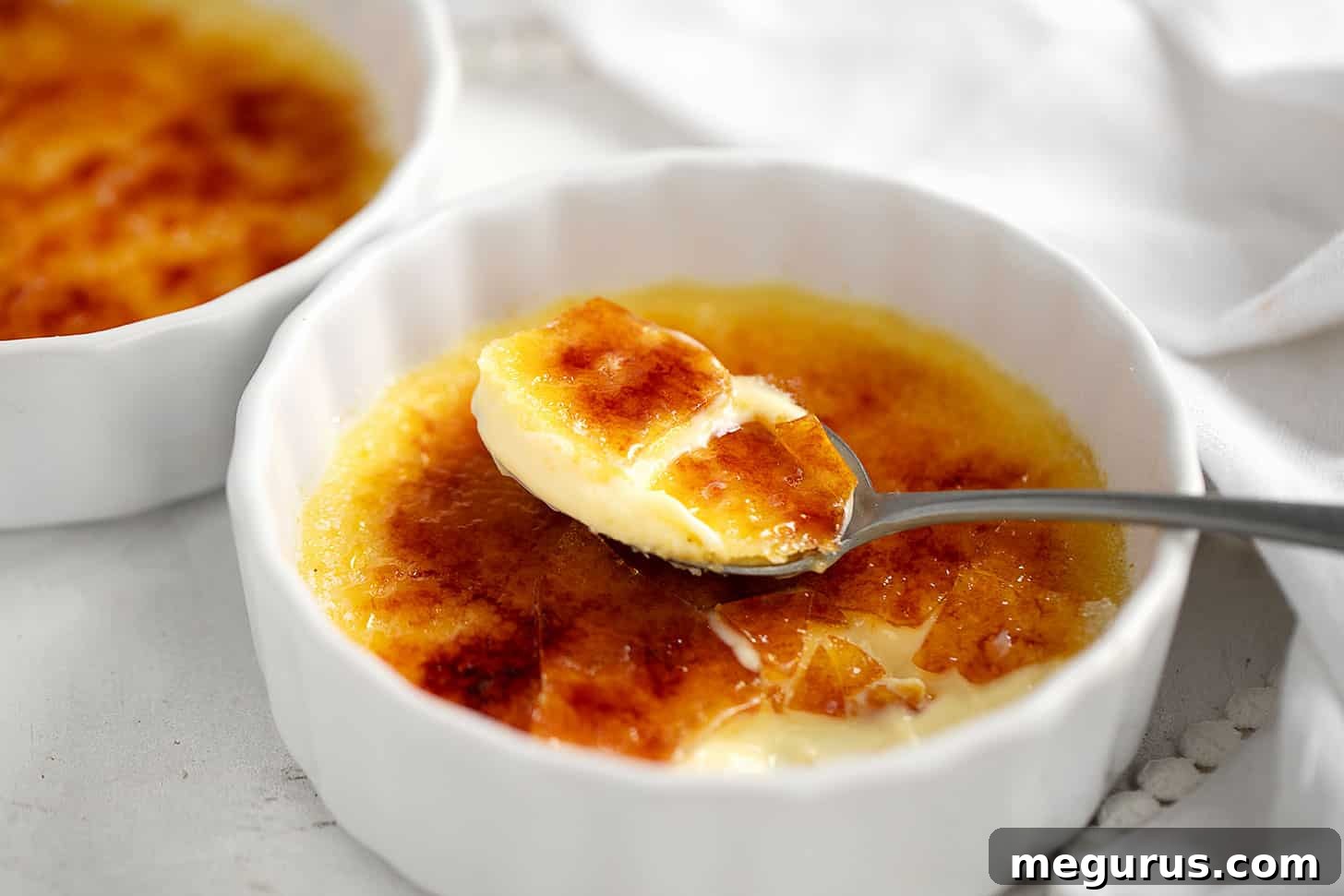 Lemon Creme Brulee in ramekin with spoon, ready to be enjoyed.